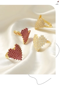 Macro view of pixel heart rings with magenta and white zircons on silk background