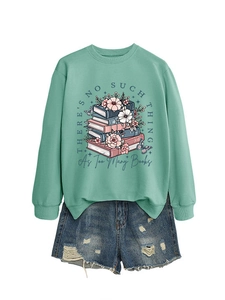 Flat lay of mint green crewneck sweatshirt with floral book print and denim shorts