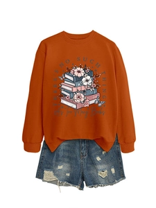 Detail of orange crewneck sweatshirt with vintage book print and ripped denim shorts