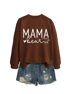 Detailed flat lay of Mama Bear sweatshirt with distressed denim shorts on white background