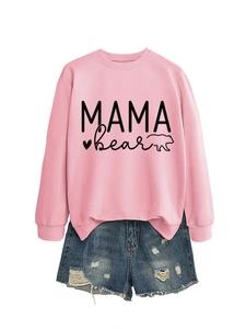Flat lay of pink MAMA BEAR sweatshirt with distressed denim shorts on white background