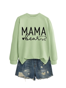 Detail of light green Mama Bear sweatshirt paired with distressed denim shorts
