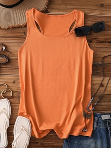 Flat lay of orange racerback tank top with denim shorts and summer vacation accessories