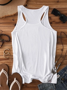 Flat lay of a white racerback tank top styled with summer accessories on wooden background