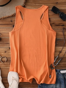 Flat lay of an orange racerback tank top paired with summer denim shorts and accessories