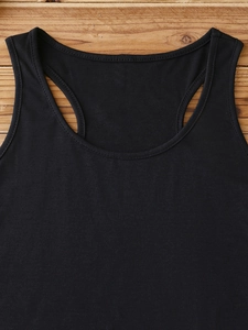 Detail shot of the fine stitching and seam work on a black ribbed cotton tank top neckline