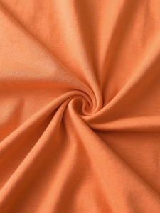 Detailed close-up of orange ribbed knit fabric texture with soft flexible folds