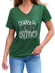 Detail of dark green V-neck T-shirt with 'Sorry Is My Teaching' white slogan print