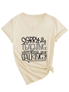 Detail of V-neck apricot T-shirt featuring SORRY IS MY TEACHING slogan and knotted hem