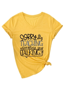 Detail of yellow V-neck T-shirt with 'Sorry Is My Teaching' print and front knot design
