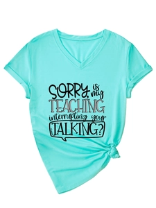 Close-up of mint green V-neck T-shirt showing rolled sleeves and front slogan print