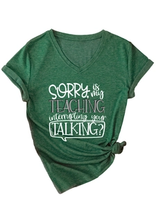 Detail of V-neck dark green T-shirt featuring rolled sleeves and printed slogan text