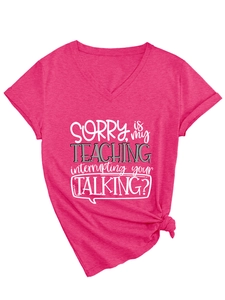 Detail of rose red V-neck T-shirt featuring SORRY is my TEACHING text and hem knot detail