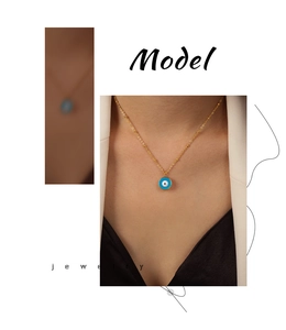 Détail du collier pendentif œil bleu en émail doré avec une fine chaîne perlée