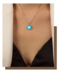 Détail d'un collier en argent avec pendentif œil maléfique en émail bleu sur le cou