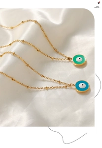 Détails de pendentifs mauvais œil en émail bleu et vert sur des chaînes à billes dorées