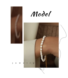 Minimalist white shell bead bracelet with gold accents and adjustable lobster clasp