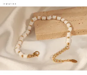 Detail of white heishi shell beads and gold titanium steel beads on handmade bracelet