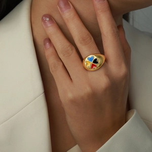 Détail d'une bague chevalière en or avec trèfle à quatre feuilles émaillé sur un mannequin
