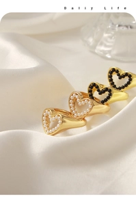 Set di quattro anelli a cuore con perle bianche e perle nere su raso bianco lucido