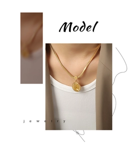 Model wearing gold snake chain necklace with round portrait coin pendant in elegant style