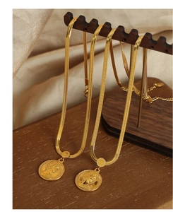 Detail of gold-plated snake chain necklaces with Elizabeth II portrait coin pendants