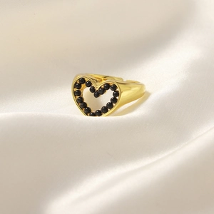 Anello dorato a forma di cuore con intarsio di perle nere su seta bianca