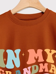 Nahaufnahme von braunem Crewneck-Sweatshirt mit In My Grandma Era Retro-Schriftzug