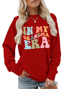 Detail eines roten Sweatshirts mit buntem In My Grandma Era Aufdruck im Retro-Blasenstil