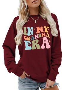 Nahaufnahme von Rippausschnitt und buntem IN MY GRANDMA ERA Aufdruck auf burgunderrotem Pulli