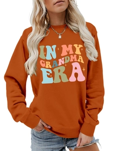 Detailansicht eines rostroten Sweatshirts mit buntem In My Grandma Era Retro-Druck