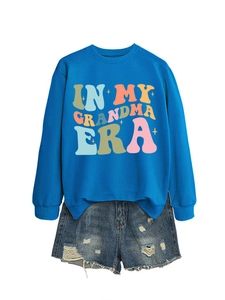 Detail von blauem Sweatshirt mit 'IN MY GRANDMA ERA' Aufdruck und Denim Shorts