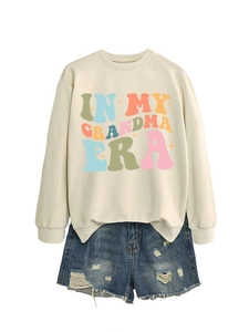 Flachbild von beige Sweatshirt mit In My Grandma Era Druck und Ripped Denim Shorts