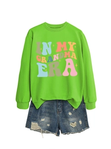 Detail von grünem In My Grandma Era Sweatshirt mit destroyed blauen Denim Shorts
