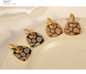 Vista macro de pendientes de esmalte geométricos con patrón de jirafa bañados en oro 18k