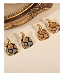 Detalle de pendientes geométricos con esmalte marrón y acabado de baño en oro de 18k