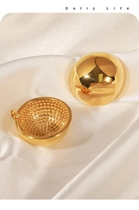 Macro shot of gold dome earrings showing smooth mirror finish and honeycomb inner texture