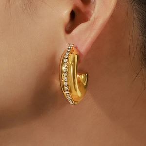 Vintage C-förmige goldene Creolen mit Zirkonia, getragen von einem weiblichen Model