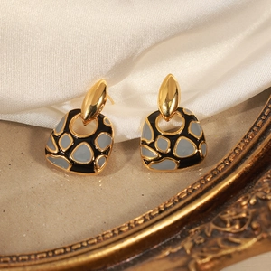 Pendientes geométricos bañados en oro de 18k con diseño de esmalte sobre seda blanca