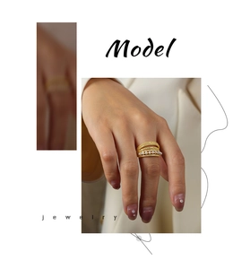 Detail of gold multi-layer ring featuring white pearls and zircon stone inlay