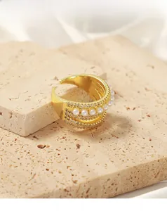 Detail of gold-plated multi-layer ring featuring faux pearls and zircon insets on stone