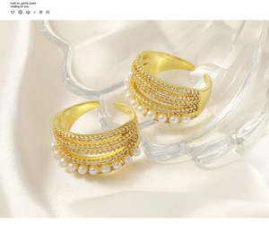 Detailed view of gold multi-layer ring with white pearls and sparkling cubic zirconia