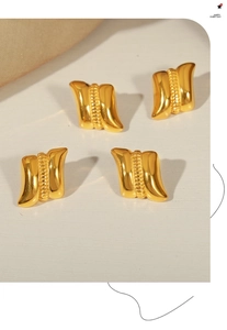 Detailed view of gold plated geometric earrings with vertical wave texture pattern