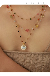 Vue détaillée du collier multi-rangs plaqué or 18k avec perles de couleur et pendentif