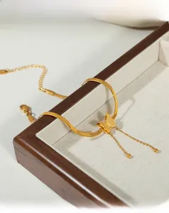 Detail of 18K gold plated butterfly anklet with snake chain and tassel on velvet