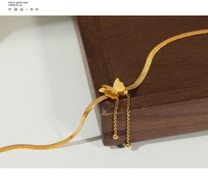 Detail of 18K gold plated titanium anklet featuring butterfly pendant and snake chain