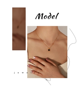 Close-up of gold plated titanium necklace with black acrylic square pendant and heart clasp
