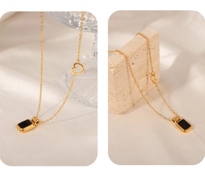 Detail of gold-plated necklace with black square pendant and hollow heart charm inlay