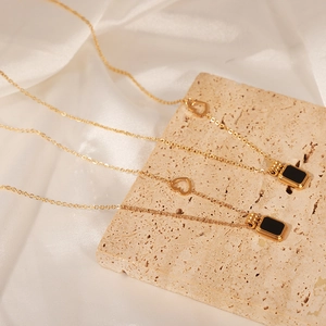 Gold plated stainless steel necklace with black rectangle pendant and heart charm