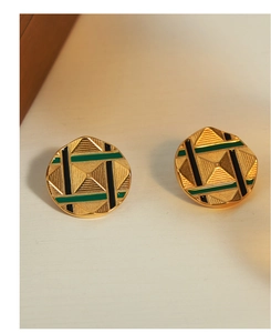 Detailed view of round gold plated stud earrings with green enamel and pyramid pattern